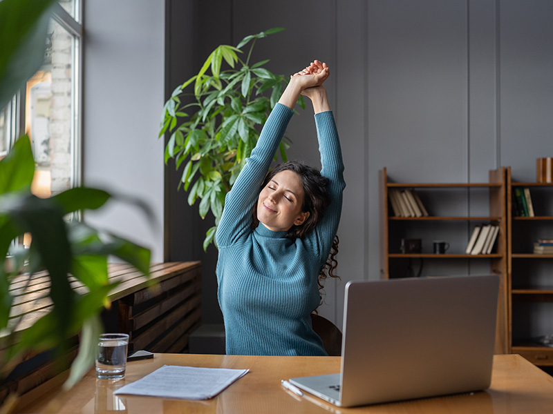 Woman stretching in front of her computer