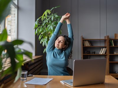 Woman stretching in front of her computer